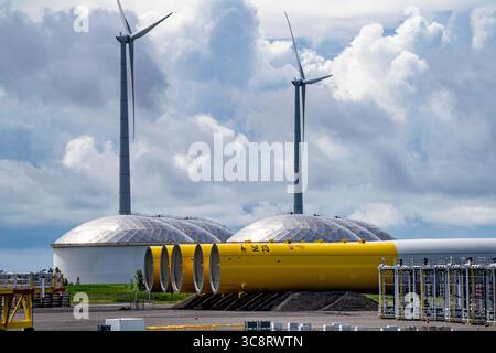 Der Seehafen von Eemshaven, Julianahaven Becken, hier lagern die Fundament-Strukturen, Monopiles, für Offshore-Windparks, die dann die eigentlichen Windräder tragen, mit großen Arbeitsschiffen werden die Bauteile zu den Windparks in der Nordsee transportiert und dort am Meeresboden verankert, darauf werden dann die Windenergieanlagen gebaut, Eemshaven, Niederlande, Windpark Logistik *** der Seehafen von Eemshaven, Julianahaven Basin, wo die Fundamentanlagen gespeichert werden. Die Komponenten werden zum W transportiert Stockfoto