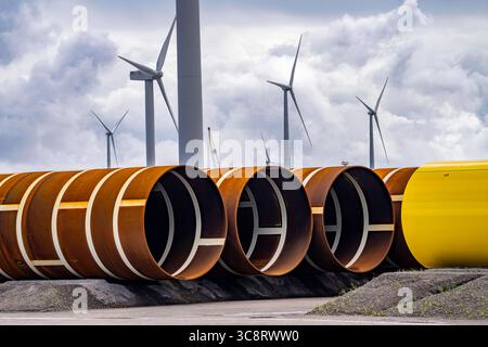 Der Seehafen von Eemshaven, Julianahaven Becken, hier lagern die Fundament-Strukturen, Monopiles, für Offshore-Windparks, die dann die eigentlichen Windräder tragen, mit großen Arbeitsschiffen werden die Bauteile zu den Windparks in der Nordsee transportiert und dort am Meeresboden verankert, darauf werden dann die Windenergieanlagen gebaut, Eemshaven, Niederlande, Windpark Logistik *** der Seehafen von Eemshaven, Julianahaven Basin, wo die Fundamentanlagen gespeichert werden. Die Komponenten werden zum W transportiert Stockfoto