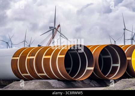 Der Seehafen von Eemshaven, Julianahaven Becken, hier lagern die Fundament-Strukturen, Monopiles, für Offshore-Windparks, die dann die eigentlichen Windräder tragen, mit großen Arbeitsschiffen werden die Bauteile zu den Windparks in der Nordsee transportiert und dort am Meeresboden verankert, darauf werden dann die Windenergieanlagen gebaut, Eemshaven, Niederlande, Windpark Logistik *** der Seehafen von Eemshaven, Julianahaven Basin, wo die Fundamentanlagen gespeichert werden. Die Komponenten werden zum W transportiert Stockfoto