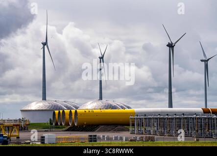 Der Seehafen von Eemshaven, Julianahaven Becken, hier lagern die Fundament-Strukturen, Monopiles, für Offshore-Windparks, die dann die eigentlichen Windräder tragen, mit großen Arbeitsschiffen werden die Bauteile zu den Windparks in der Nordsee transportiert und dort am Meeresboden verankert, darauf werden dann die Windenergieanlagen gebaut, Eemshaven, Niederlande, Windpark Logistik *** der Seehafen von Eemshaven, Julianahaven Basin, wo die Fundamentanlagen gespeichert werden. Die Komponenten werden zum W transportiert Stockfoto
