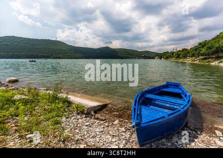 Schöner Blick auf den Abrau-Durso-See in den Bergen des Kaukasus in Russland mit dem Boot im Vordergrund Stockfoto