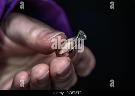 Ein Juwelier hält hinter den Kulissen in einer Schmuckwerkstatt auf dem Großen Basar in Istanbul, Türkei, einen fertig funkelnden Solitärring mit Diamanten Stockfoto