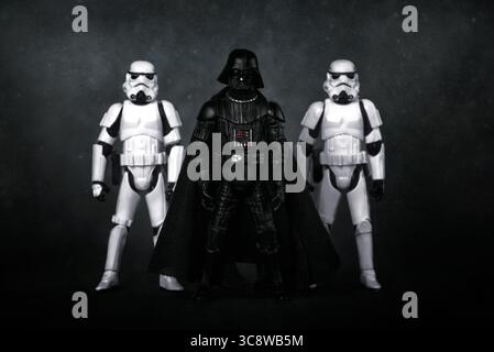 Darth Vader und Stormtroopers Actionfiguren aus der Star Wars-Filmsaga auf dunklem Hintergrund. Illustrativer Leitartikel Stockfoto