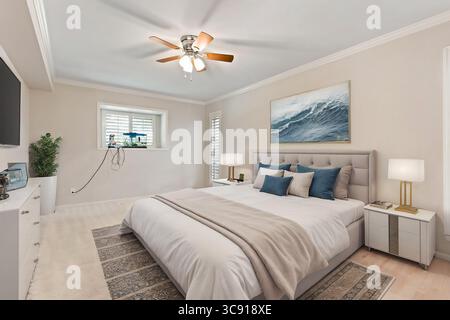 Ein Schlafzimmer mit einem großen Bett, Deckenventilator, Fernseher und einem Fenster Stockfoto
