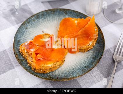 Zwei köstliche Sandwiches mit geräuchertem Lachs, serviert auf Teller Stockfoto