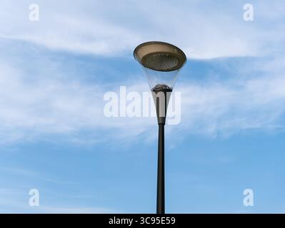 Elegante Straßenlaterne auf einem Stab vor einem bewölkten Himmel. Stockfoto