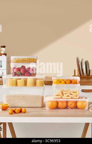 Stapel von durchsichtigen Kunststoff-Lebensmittel-Aufbewahrungsbehältern mit verschiedenen Lebensmitteln, gesunde Lebensmittel in Plastikboxen auf dem Tisch in der Küche Stockfoto