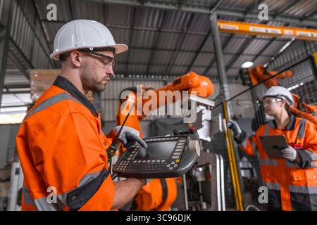 Techniker Techniker Techniker Team reparieren Service Wartung Inspektion automatische Roboterarm Maschine Installation in modernen Fabrik. Arbeiter prüfen die Reparatur der Einstellung Stockfoto