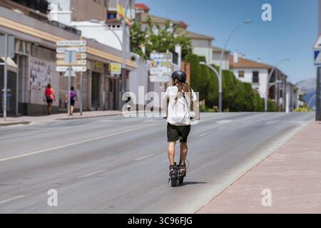 Ronda, malaga, spanien 20. juni 2022 junger Mann mit Dreadlocks auf einem elektrischen Skateboard, der auf der Autobahn fährt Stockfoto