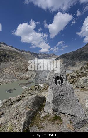 Großer Granitstein markiert die Quelle der Rhone, dahinter ein Panoramablick auf den Rhonegletscher, Zentralalpen, Kanton Wallis, Schweiz Stockfoto