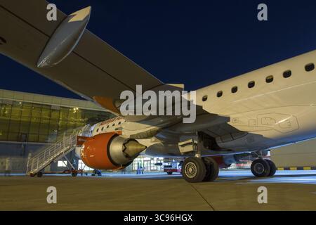 Nairobi, Kenia - 26. August 2014: Blick auf die leuchtend weiß-orange Flugzeuge vor dem blau-blauen Nachthimmel, gegenüber dem Terminalgebäude. Stockfoto