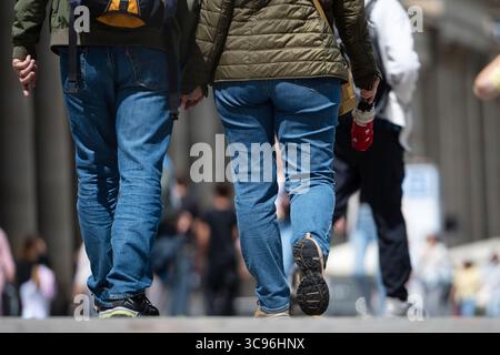 Stuttgart, Deutschland. August 2025. Zwei Personen gehen Hand in Hand durch die Fußgängerzone in Stuttgart. Andere Passanten sind im Hintergrund zu sehen. Quelle: Markus Lenhardt/dpa/Alamy Live News Stockfoto
