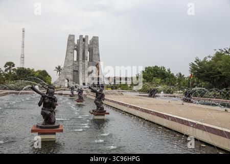 Accra, Ghana - 27. Mai 2017: Blick auf den weißen Stein des Kwame Nkrumah Mausoleums vor dem düsteren Himmel, reflektiert im ruhigen Wasser des Brunnens, mit Bronzestatuen, die bewacht werden. Stockfoto