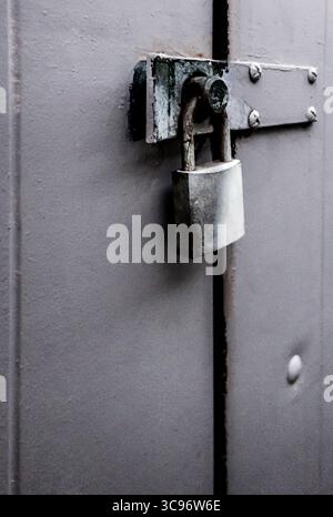 Eine Nahaufnahme eines Vorhängeschlosses, das eine Tür sichert. Stockfoto