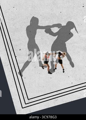 Collage zweier weiblicher Boxer mit dramatischen Schattensilhouetten in dynamischer Pose auf neutralem, strukturiertem Hintergrund Stockfoto