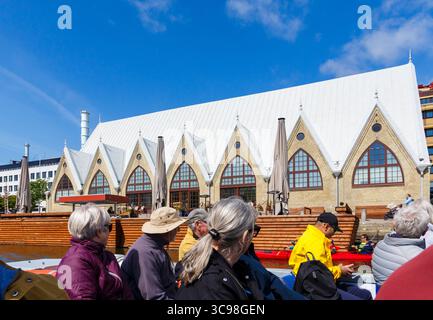 Bootsgäste sehen die Kirchhalle des Feskekorka Fischmarktes, während sie im Mai auf einem Ausflugsboot in Göteborg, Schweden, vorbeifahren Stockfoto