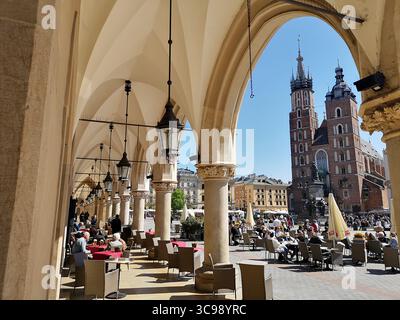 Krakaus Hauptplatz, bekannt als Rynek Główny, mit den Bögen der Tuchhalle Sukiennice und den Doppeltürmen der Marienkirche. Stockfoto