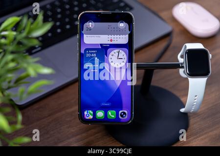 Poznan, Polen – 29. Juli 2025: Nahaufnahme des Apple iPhone und der Apple Watch mit innovativer ios 26-Schnittstelle mit Flüssigglas-Design, Hervorhebungsmodus Stockfoto