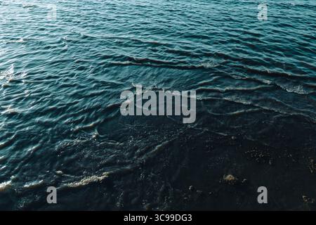 Nahaufnahme des ruhigen Meerwassers mit sanften Wellen und dunklen Blautönen, die die friedliche und beruhigende Schönheit der Meeresoberfläche einfangen Stockfoto