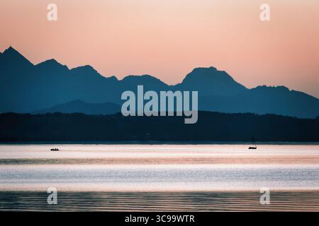 Beeindruckender Blick über den Chiemsee mit Blick auf die Alpen bei Sonnenuntergang und Reflexionen auf dem Wasser Stockfoto