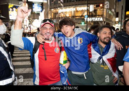 27. November 2022, Tokio, Japan: Costa-ricanische Touristen feiern mit japanischen Fußballfans beim Shibuya Scramble in Tokio, nachdem Costa Rica Japan in einem Gruppenspiel der Katar-Weltmeisterschaft 2022 mit 1:0 besiegt hatte. Costa Rica und Japan sind jetzt auf Punkte gesetzt, aber Japan liegt vor dem Tor Differential und wetteift um einen Platz, um eine harte Gruppe E zu überleben und in die Achtelfinale aufzusteigen... Fußball, Fußball, FIFA-Weltmeisterschaft, japanische Fußballnationalmannschaft, Samurai Blue, Tokio. (Bild: © Taidgh Barron/ZUMA Press Wire) Stockfoto