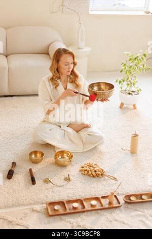 Achtsame Klangmeditation mit Klangschale, Kerzen und Wellness-Ritual zur Entspannung zu Hause Stockfoto