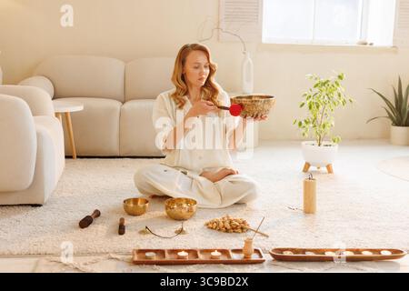 Meditationssitzung mit Klangschale, Kerzen und Wellness-Ritual zu Hause für Entspannung und Achtsamkeit Stockfoto