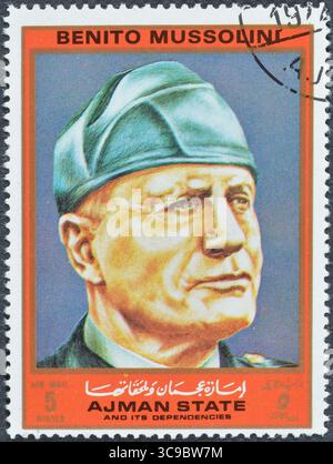 Gestempelte Briefmarke von Ajman, die das Porträt von Benito Mussolini zeigt, um 1972. Stockfoto