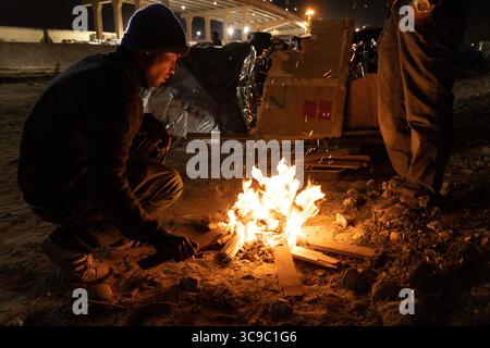 10. November 2022, juarez, chihuahua, mexiko: Migranten erhitzen Wasser in einem Lagerfeuer, um Kaffee zuzubereiten, während sie in Ciudad JuÃ¡rez am Ufer des Rio Grande auf die Eliminierung des Titels 42 warten (Foto: © David Peinado/ZUMA Press Wire) Stockfoto