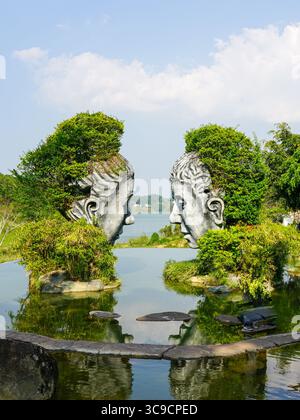 Da Lat, Vietnam, 24. März 2025: Skulpturen von Angesicht zu Angesicht reflektieren über dem ruhigen Wasser im da Lat Love Park Stockfoto