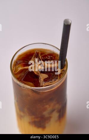 Köstlich gekühlter Eiskaffee mit Eiswürfeln und Strohhalm perfekt für erfrischende heiße Tage Stockfoto
