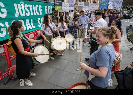BRASILIANISCHE BOTSCHAFT, LONDON, Großbritannien – 05. August 2025: Demonstranten versammeln sich vor der brasilianischen Botschaft und rufen Präsident Lula auf, gegen das sogenannte „Verwüstungsgesetz“ zu verstoßen, das angeblich die Rechte der Indigenen bedroht, den Umweltschutz schwächt und die Entwaldung im Amazonasgebiet beschleunigt. Der von Brazil Matters organisierte Protest nutzte Lärm, Banner und symbolische Aktionen, um die Aufmerksamkeit auf die potenziellen Auswirkungen des Gesetzes auf die biologische Vielfalt, die indigenen Gemeinschaften und das globale Klima zu lenken. Stockfoto