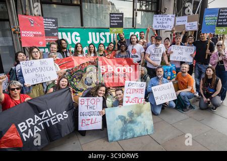 BRASILIANISCHE BOTSCHAFT, LONDON, Großbritannien – 05. August 2025: Demonstranten versammeln sich vor der brasilianischen Botschaft und rufen Präsident Lula auf, gegen das sogenannte „Verwüstungsgesetz“ zu verstoßen, das angeblich die Rechte der Indigenen bedroht, den Umweltschutz schwächt und die Entwaldung im Amazonasgebiet beschleunigt. Der von Brazil Matters organisierte Protest nutzte Lärm, Banner und symbolische Aktionen, um die Aufmerksamkeit auf die potenziellen Auswirkungen des Gesetzes auf die biologische Vielfalt, die indigenen Gemeinschaften und das globale Klima zu lenken. Stockfoto