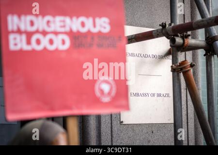 BRASILIANISCHE BOTSCHAFT, LONDON, Großbritannien – 05. August 2025: Demonstranten versammeln sich vor der brasilianischen Botschaft und rufen Präsident Lula auf, gegen das sogenannte „Verwüstungsgesetz“ zu verstoßen, das angeblich die Rechte der Indigenen bedroht, den Umweltschutz schwächt und die Entwaldung im Amazonasgebiet beschleunigt. Der von Brazil Matters organisierte Protest nutzte Lärm, Banner und symbolische Aktionen, um die Aufmerksamkeit auf die potenziellen Auswirkungen des Gesetzes auf die biologische Vielfalt, die indigenen Gemeinschaften und das globale Klima zu lenken. Stockfoto