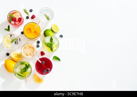 Eisgetränke auf weißem Hintergrund. Limonade, Mojito, Himbeer-Limonade, Tonic Water mit frischem Obst. Draufsicht mit Platz für Text. Stockfoto