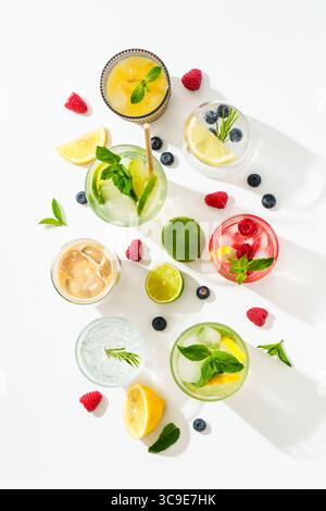 Sommergetränke, farbige Cocktails auf weißem Hintergrund. Limonade, Mojito, Himbeer-Limonade, Tonic Water und Eiskaffee. Vertikales Bild. Stockfoto