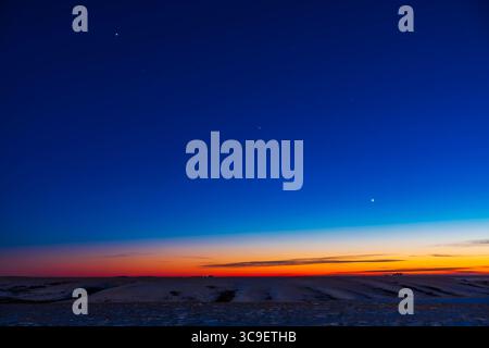 17. Dezember 2021, Alberta, Kanada: Die Aufstellung von drei Abendplaneten am südwestlichen Dämmerhimmel, am 17. Dezember 2021 â€“ mit Jupiter oben links, Venus unten rechts und dunklem Saturn in der Mitte, die alle die Linie der Ekliptik am kalten Winterhimmel in dieser Nacht definieren. Die Stars von Capricornus sind im Zentrum. ..Eine einzelne 6s-Aufnahme mit dem Canon RF-Objektiv von 28 bis 70 mm bei 39 mm und Canon Ra bei ISO 100. V2 dieses Bildes wurde 10 Minuten später mit weniger intensiven Dämmerungsfarben, aber mehr Sternen an einem dunkleren Himmel und einem helleren, mondbeleuchteten Vordergrund aufgenommen. (Kreditbild: © Alan Dyer/VW Pics Via Z Stockfoto