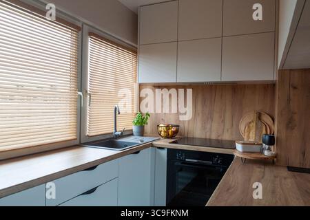 Kleine gemütliche, moderne Holzküche mit Holzläden Stockfoto