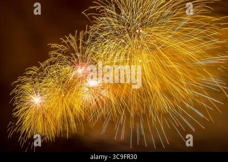 Erstaunliche gelbe Feuerwerke explodieren mit glitzernden Ergebnissen in Moskau, Russland. 23. Februar. Stockfoto