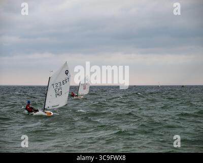 Jugendsegelwettbewerb auf der Ostsee mit Optimist-Jollen unter bewölktem Himmel Stockfoto