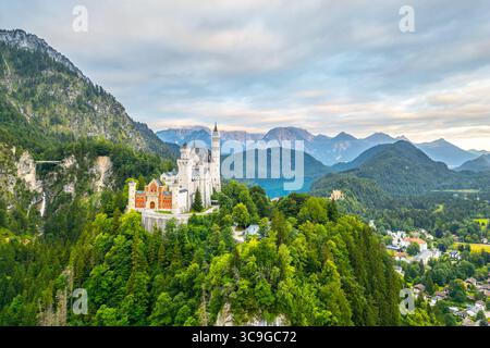 Schloss Neuschwanstein erhebt sich dramatisch über saftig grünen Wäldern und Bergen in Bayern. Dieses märchenhafte Schloss besticht durch seine bezaubernde Architektur und seine malerische Umgebung. Stockfoto