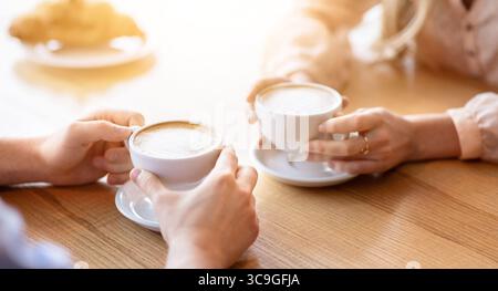 Liebevolles junges Paar auf Datum im Café, Kaffee trinken zusammen, beschnitten Blick auf die Hände Stockfoto