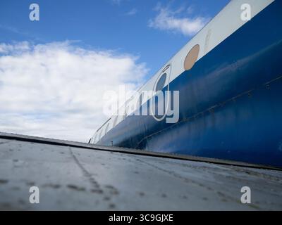 Flachwinkelansicht des Rumpfes und der Fenster kleiner Flugzeuge unter blauem Himmel, der allgemeinen Luftfahrt oder der regionalen Passagierflugzeuge Stockfoto