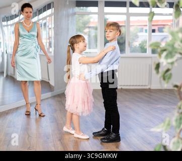 Tween Junge und Mädchen, die Walzer zu zweit in der Tanzhalle spielen Stockfoto