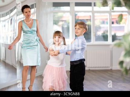 Tween Junge und Mädchen, die Walzer zu zweit in der Tanzhalle spielen Stockfoto