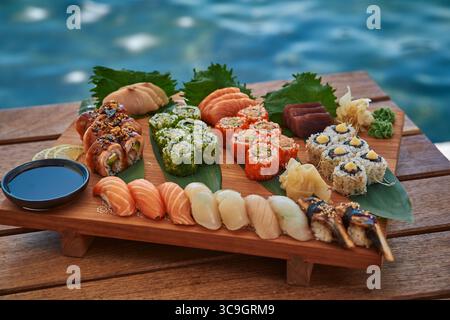 Eine wunderschön angeordnete Sushi-Platte mit einer lebendigen Vielfalt an frischen Zutaten, mit verschiedenen Arten von Sushi und Begleitungen auf einer Woo-Note Stockfoto