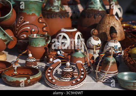 Bunte handgemachte Töpferwaren auf einem Markt. Verschiedene Formen und Größen, einschließlich Töpfe, Figuren und dekorative Gegenstände. Satte Erdtöne und Intr Stockfoto