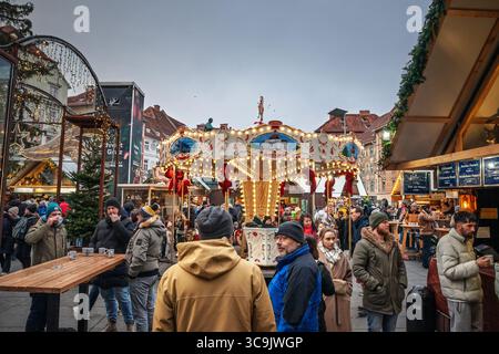 GRAZ, ÖSTERREICH - 17. DEZEMBER 2024: Hauptplatz in Graz in der Adventszeit mit beleuchtetem Karussell, Ständen und festlichen Lichtern. Menschenmassen trinken Gluhwein im Chri Stockfoto
