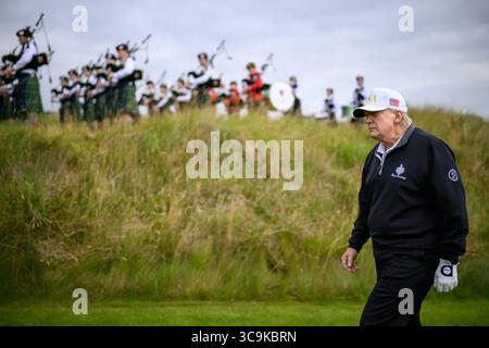 Präsident Donald J. Trump spaziert auf dem Golfplatz von Trump Turnberry, während eine schottische Dudelsackband während seines Besuchs in Schottland auftritt. Dieser Moment verschmolz Tradition und persönliche Geschäfte während seiner fünftägigen diplomatischen Reise. Schottland. Juli 2025. Bild mit freundlicher Genehmigung des Weißen Hauses. Stockfoto