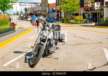 Ein klassisches Harley Davidson FLSTF Fat Boy Motorrad aus dem Jahr 2004 mit American Flag und Eagle Helm im Zentrum von Sturgis, dem Ort der Motorradrallye. Stockfoto
